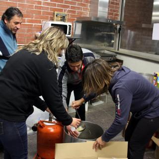Voluntaris reparteixen caldo calent entre les persones evacuades per l'incendi al Baix Empordà, aquesta nit al pavelló de Sant Jordi Desvalls