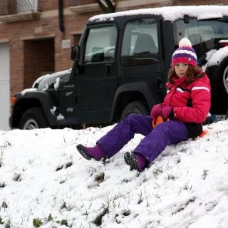 Una nena baixant de cul per la neu a Tàrrega