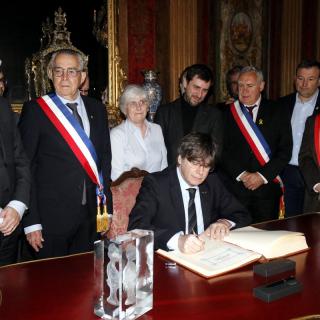 L'expresident de la Generalitat i eurodiputat Carles Puigdemont signant el llibre d'honor de l'Ajuntament de Perpinyà