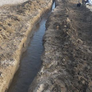 Els veïns obren una rasa (a pala) d'uns 80 metres a la platja per poder truere l'aigua del poble.