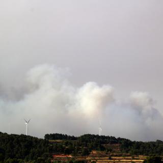 Fum de l'incendi de Corbera d'Ebre, darrera un parc eòlic