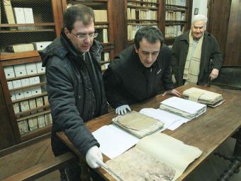 El rector David Compte, i Jordi Vilarrodà i Alfons Calvo, de la Junta del Monestir, a l’arxiu del monestir Jordi Puig