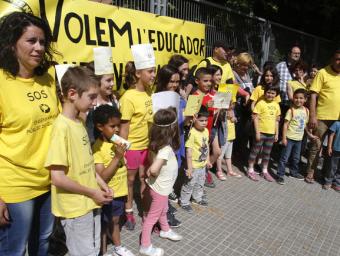 Membres de l’AMPA al davant de la pancarta que han penjat a la tanca de l’escola Griselda Escrigas