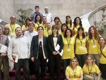 Els pares, mares i mestres del Sant Vicenç a les escales del Parlament amb alguns diputats de diversos partits