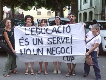 Membres de la CUP van desplegar una pancarta en contra de la reducció de personal a la llar d’infants Isaac Muntadas