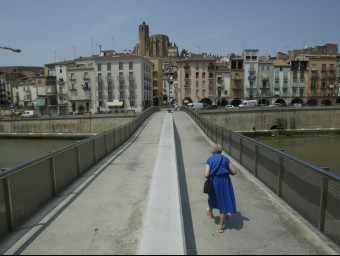 Una dona camina per una passarel·la sobre el riu Segre a Balaguer. ANDREU PUIG