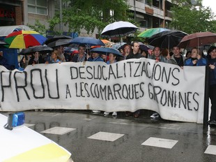 Els treballadors que es van manifestar ahir a la tarda a Girona van tallar el carrer de la Creu, desafiant la pluja.  LLUÍS SERRAT