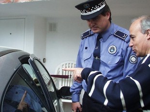 Un policia aten un ciutadà al qual han forçat el cotxe en una imatge d'arxiu.  EL PUNT