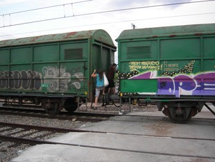 Usuaris del tren passant entre dos vagons de mercaderies per accedir al seu comboi.