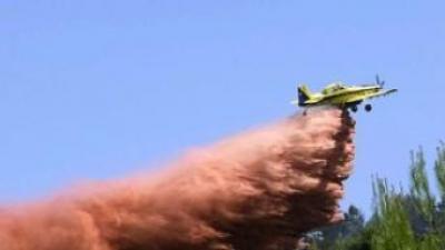 Un avió col·labora en l'extinció del foc a la Vall de Gallinera.  EFE