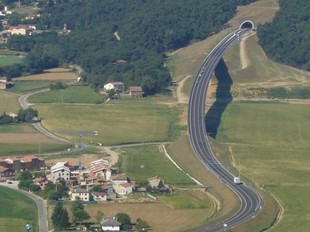 La carretera C-37 a la Vall d'en Bas. Al centre de la imatge, el veïnat de can Trona, el viaducte de Rubió i la boca est del túnel de la Codina.  R. E