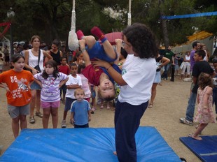 Un nen fa una tombarella en un trapezi durant el taller de circa la plaça de Catalunya de Terrassa.  M.A.L