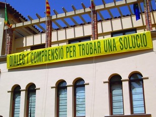 L'alcalde ha penjat una pancarta a l'ajuntament demanant diàleg per solucionar el conflicte.