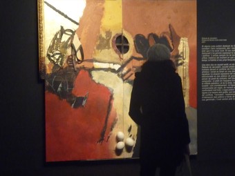 Una dona mira el «Retaule de Jerusalem» de Guinovart al Museu de Lleida.  D.M