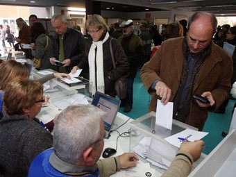 Un home, a la dreta de la imatge, diposita un vot a l'urna, el passat 13 de desembre a Sant Cugat del Vallès.  ORIOL DURAN