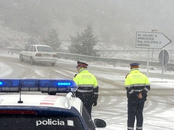 Els Mossos d'Esquadra controlant el trànsit en un dels accessos a l'eix transversal, que es va haver de tallar per la neu.  ROBIN TOWNSEND / EFE