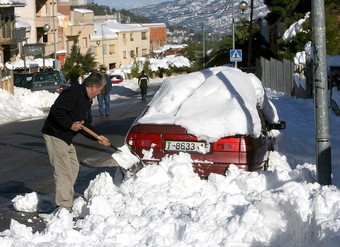 Un veí d'Horta de Sant Joan, netejant el cotxe de neu amb la pala EFE