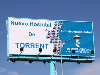 El cartell està en castellà i anuncia el lloc en que s'hi bastirà el nou hospital. /  ARXIU