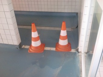 Cons de senyalització per impedir el pas a les dutxes de la piscina coberta de la Cotxera.