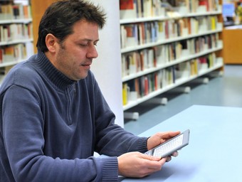 Un usuari amb un llibre electrònic a la biblioteca Pare Miquel d'Esplugues de Llobregat.