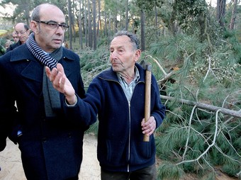 El conseller de Medi Ambient, Francesc Baltasar, acompanyat d'un propietari forestal ahir en un bosc de Cassà de la Selva mol malmès. MANEL LLEDÓ