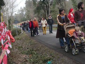 Els participants en la passejada, davant un munt d'estaques que marcaven l'eixamplament. A.V