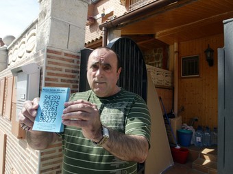 El propietari de l'immoble, Manuel Galván, mostrant una de les paperetes del sorteig que ha ideat.  JUDIT FERNÀNDEZ