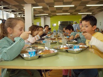 Imatge d'arxiu d'un grup de nens menjant en un menjador escolar.  R. LARNSDORFF