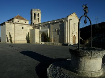 El pou que hi ha al centre de la llotja natural i, al fons, l'església romànica de Santa Maria.  JUANMA RAMOS