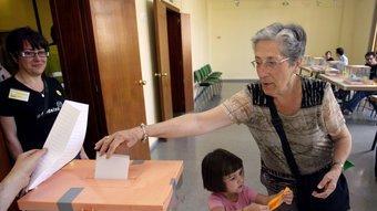 Una votant veterana, dipositant la papereta amb la seva néta.  JUANMA RAMOS