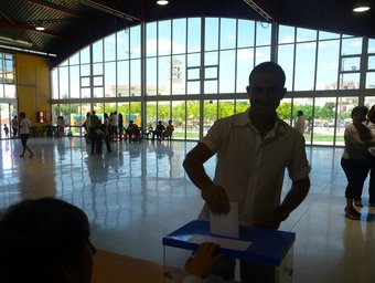 Un veí de Móra la Nova diposita el vot en la mesa electoral del pavelló firal. G.M