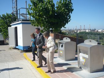 Els responsables de Repsol i de Medi Ambient, ahir a l'estació de mesura de Puigdelfí, amb el polígon al fons.  Ò.P.J