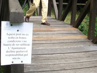 Un senyor travessa un pont de fusta en males condicions a Santa Pau. Tura Soler