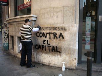 Un operari neteja una pintada l'endemà de la vaga general.  JOSEP LOSADA