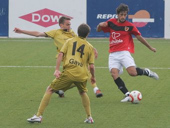 Un jugador de la Pobla, intentant superar la pressió de dos rivals.  MARTA MARTÍNEZ