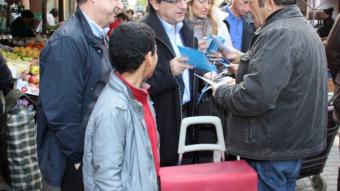 Josep Enric Millo, al centre, fent campanya ahir al matí al mercat de Palafrugell ACN
