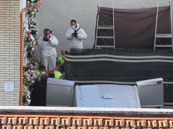 Els operaris de la funerària treuen un dels fèretres al cementiri d'Olot mentre la policia científica dels Mossos fotografia i enregistra l'operació. JOAN CASTRO / CLICK ART FOTO