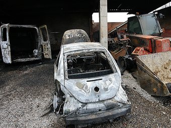 Els dos vehicles cremats i la retroexcavadora, afectada, a Cornellà del Terri. M. LLADÓ