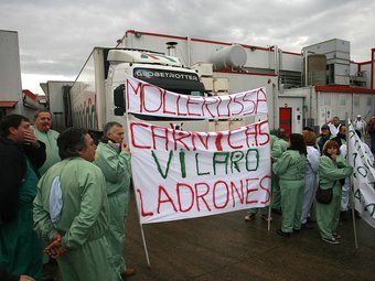 Els manifestants concentrats a l'empresa, amb pancartes reivindicatives. MANEL LLADÓ