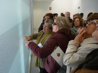 Les dones cerquen el nom als barandats de vidre de la Casa de la Dona. ESCORCOLL