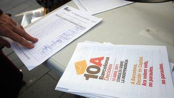 Una taula de recollida de vot anticipat amb el registre dels DNI de la gent que ha votat i un tríptic de la consulta sobre la independència de Catalunya ORIOL DURAN