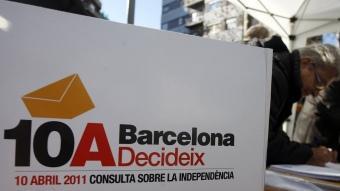 Una persona vota en una de les parades de recollida de vot anticipat al carrer que s'organitzen a la ciutat de Barcelona ORIOL DURAN