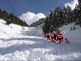 Un grup de rescatadors inspeccionen la zona per on ha baixat l'allau de neu, que agafava una amplada de 10 metres. BOMBERS DE LA GENERALITAT