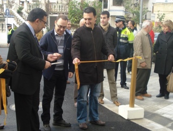 Domingo Alcalà sosté la cinta durant la inauguració del carrer del Riu. EL PUNT