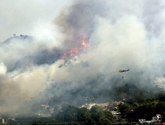 Un helicòpter s'acosta a les flames, el passat dissabte. EFE