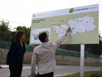 L'alcaldessa i el regidor d'agricultura observen el mapa de camins rurals. CEDIDA