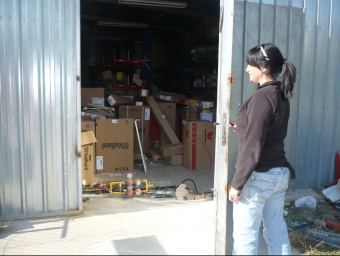 Una noia mostra la porta que els lladres van forçar per entrar al magatzem. ALBERT VILAR