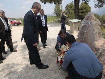 Felip Puig acompanyat per dos bombers del parc posant les flors al monòlit. J.C.LEÓN