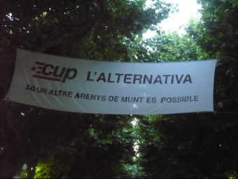 Una de la pancartes electorals de la CUP penjades als arbres de la riera. E. FERRAN