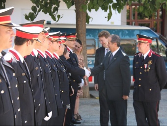 Puig acompanyat per l'alcalde Ferran Bel, saludant els agents poc abans d'entrar al Centre Cívic de Ferreries. R.R